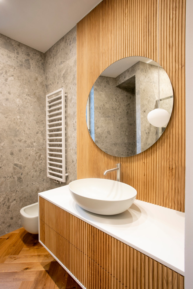Источник вдохновения для домашнего уюта: ванная комната среднего размера в стиле модернизм с серыми фасадами, душем в нише, инсталляцией, серой плиткой, керамогранитной плиткой, серыми стенами, темным паркетным полом, душевой кабиной, настольной раковиной, столешницей из искусственного камня, коричневым полом, душем с раздвижными дверями, белой столешницей, тумбой под одну раковину, подвесной тумбой, многоуровневым потолком и деревянными стенами