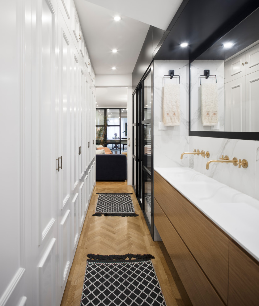 Photo of a mid-sized contemporary 3/4 bathroom in Other with flat-panel cabinets, brown cabinets, a shower/bathtub combo, white tile, white walls, medium hardwood floors, an integrated sink, beige floor, a sliding shower screen and white benchtops.