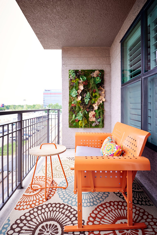 petit balcon avec mobilier orange et mur végétalisé