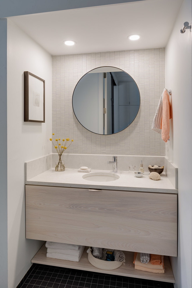 Small contemporary master bathroom in Boston with flat-panel cabinets, light wood cabinets, a drop-in tub, a shower/bathtub combo, a one-piece toilet, beige tile, ceramic tile, white walls, porcelain floors, an undermount sink, granite benchtops, black floor, a shower curtain and white benchtops.