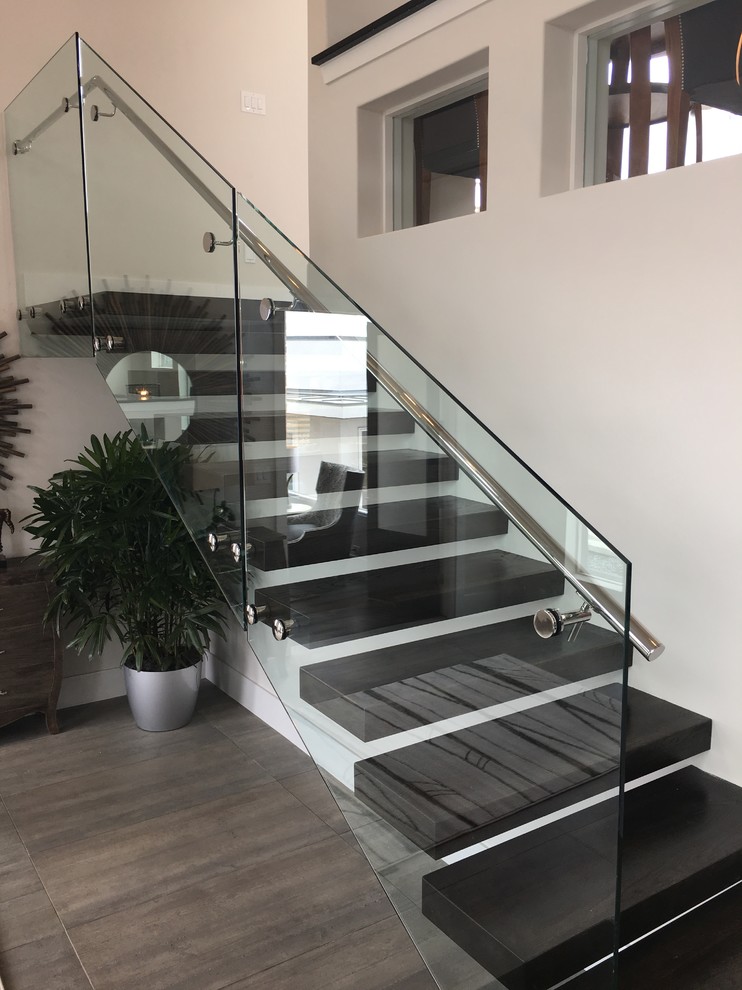 Photo of a contemporary wood floating staircase in Austin with metal railing.