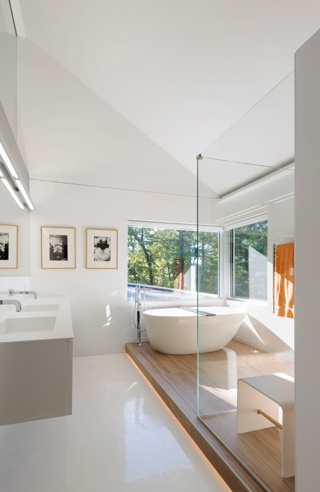 This is an example of a large contemporary master bathroom in San Francisco with an integrated sink, white cabinets, a freestanding tub, a corner shower, white walls, flat-panel cabinets, white tile, white floor, a hinged shower door and a floating vanity.