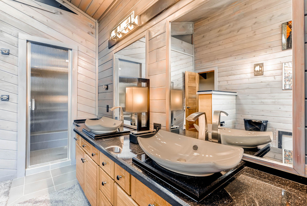 Bathroom - mid-sized rustic master black tile concrete floor bathroom idea in Denver with flat-panel cabinets, light wood cabinets, a one-piece toilet, brown walls, a vessel sink and quartzite countertops