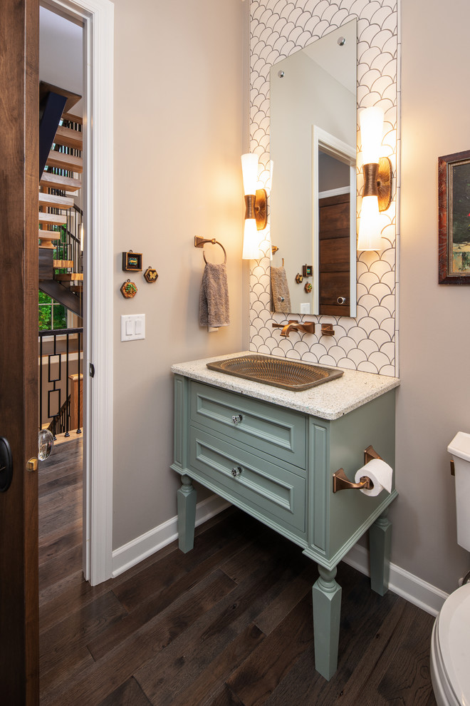 Transitional powder room in Omaha with recessed-panel cabinets, turquoise cabinets, white tile, grey walls, dark hardwood floors, a drop-in sink, brown floor and white benchtops.