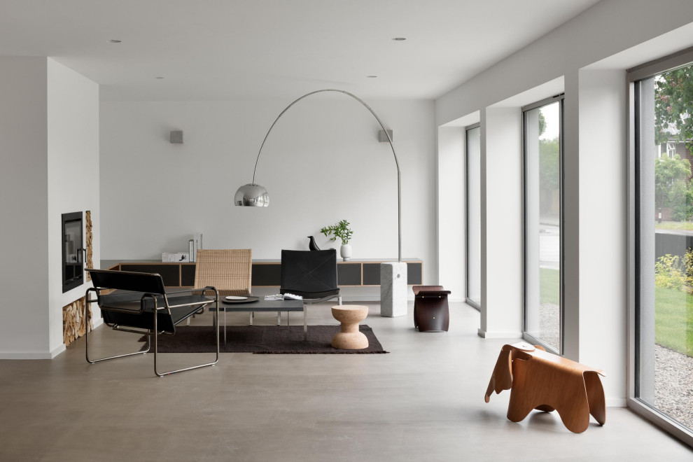 Imagen de salón abierto minimalista grande sin televisor con paredes blancas, estufa de leña y suelo marrón