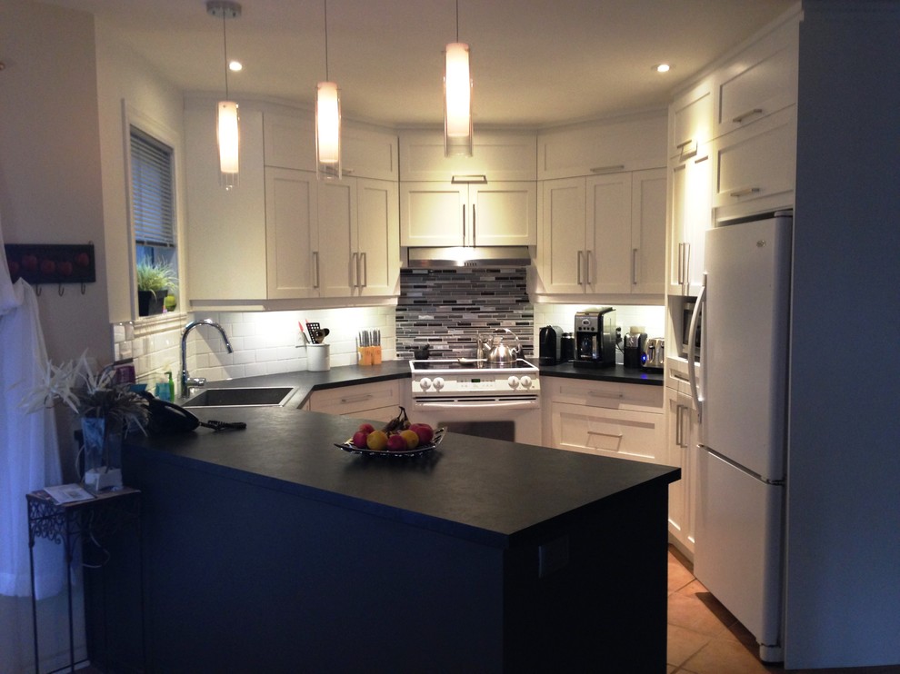 Small transitional u-shaped separate kitchen in Montreal with a drop-in sink, shaker cabinets, white cabinets, quartzite benchtops, white splashback, ceramic splashback, white appliances, terra-cotta floors, a peninsula and brown floor.