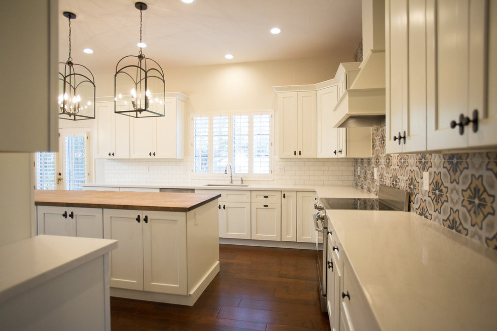 Inspiration for a mid-sized transitional u-shaped dark wood floor enclosed kitchen remodel in Phoenix with an undermount sink, shaker cabinets, white cabinets, quartz countertops, multicolored backsplash, porcelain backsplash, stainless steel appliances and an island