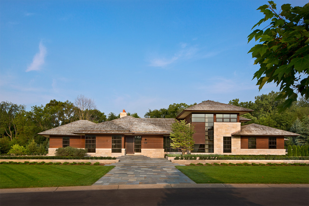 Large contemporary two-storey brown house exterior in Detroit with wood siding, a hip roof and a shingle roof.