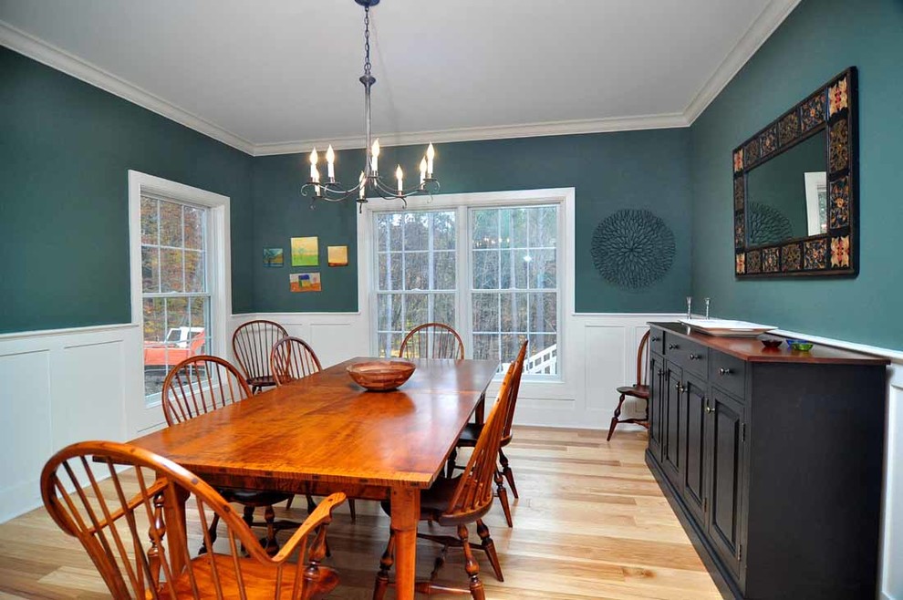 Design ideas for a mid-sized country separate dining room in New York with green walls, light hardwood floors, no fireplace and brown floor.