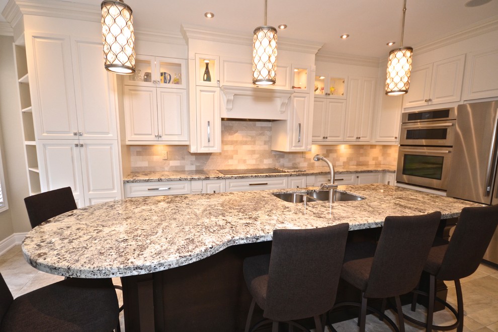 Example of a mid-sized transitional l-shaped porcelain tile enclosed kitchen design in Toronto with an undermount sink, raised-panel cabinets, white cabinets, granite countertops, beige backsplash, stainless steel appliances and an island
