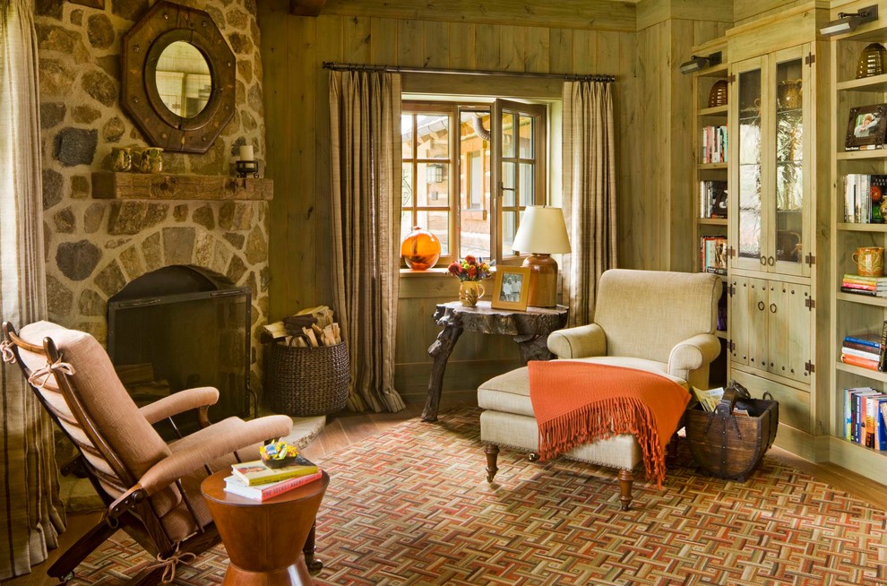 Photo of a country family room in New York with a library, a corner fireplace and a stone fireplace surround.