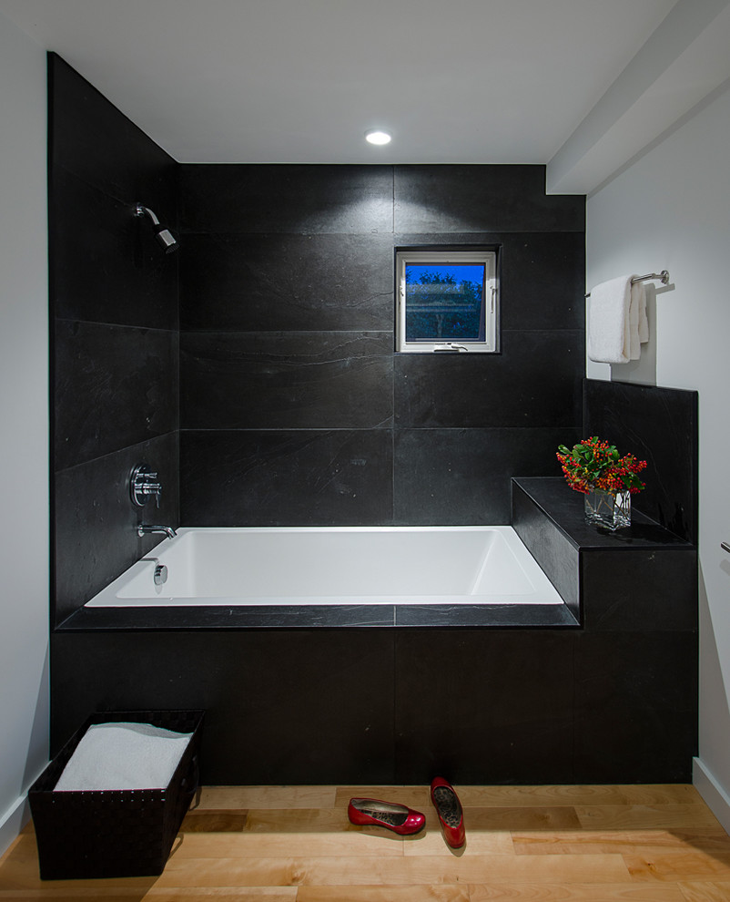 This is an example of a mid-sized contemporary master bathroom in Burlington with slate, a drop-in tub, an open shower, black tile, light hardwood floors and an open shower.