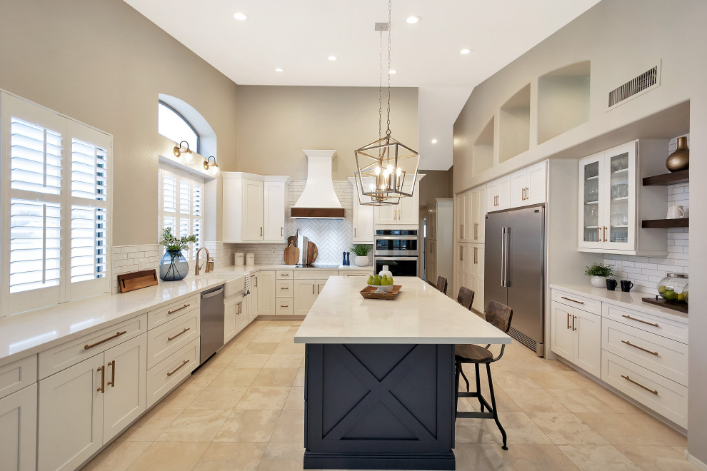 Example of a large transitional u-shaped open concept kitchen design in Phoenix with a farmhouse sink, shaker cabinets, white cabinets, quartz countertops, white backsplash, subway tile backsplash, stainless steel appliances, an island and white countertops