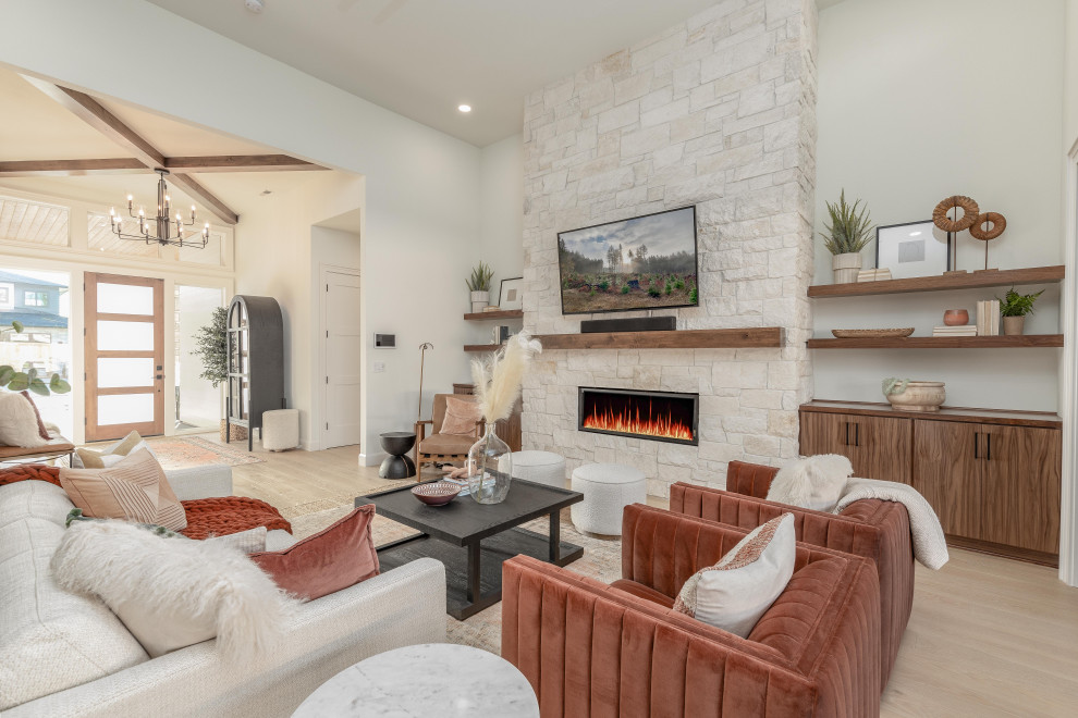 Inspiration for a large open concept family room in Portland with white walls, light hardwood floors, a standard fireplace, a stone fireplace surround, a wall-mounted tv and brown floor.