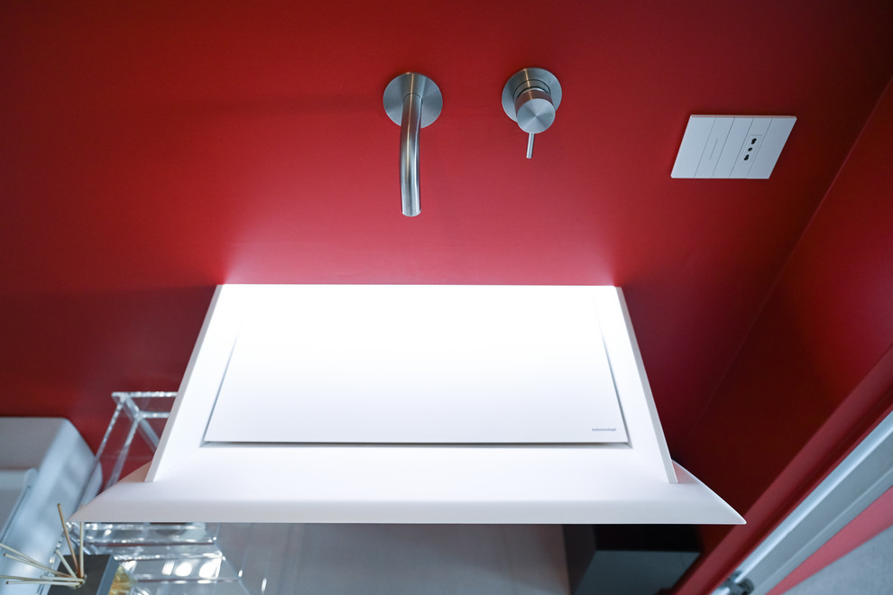 Photo of a small modern powder room in Rome with open cabinets, a wall-mount toilet, red tile, red walls, porcelain floors, a console sink and white floor.