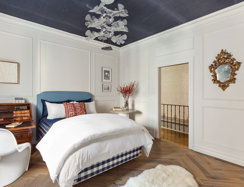 This is an example of a mid-sized transitional master bedroom in New York with white walls, medium hardwood floors and brown floor.