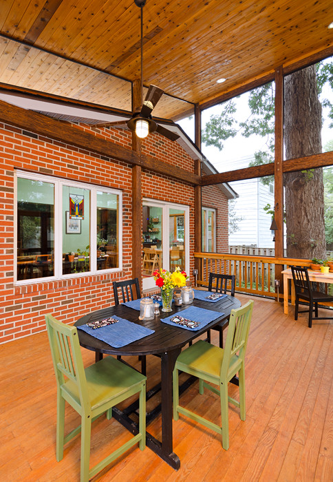 This is an example of a mid-sized asian screened-in verandah in DC Metro with decking and a roof extension.