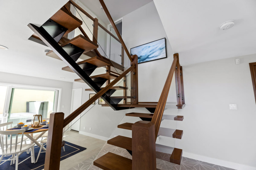 Photo of a large transitional painted wood l-shaped staircase in Los Angeles with glass railing.