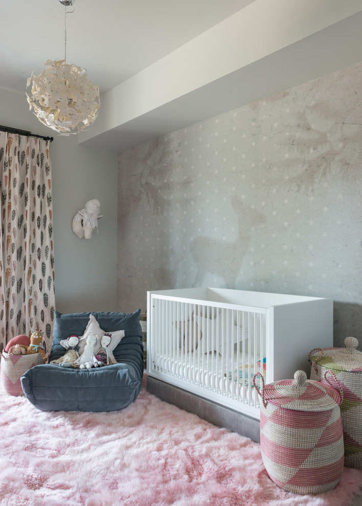 This is an example of a medium sized rustic nursery for girls in Other with wallpapered walls.