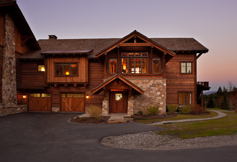 Design ideas for a large country three-storey brown house exterior in Other with wood siding, a gable roof and a shingle roof.