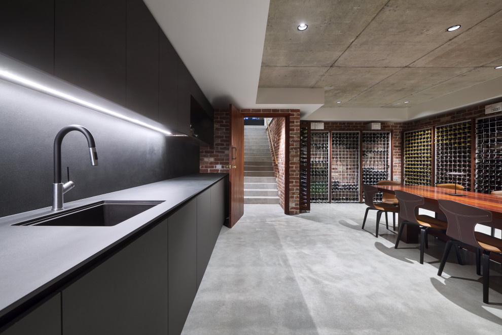 Large modern wine cellar in Perth with concrete floors, storage racks and grey floor.