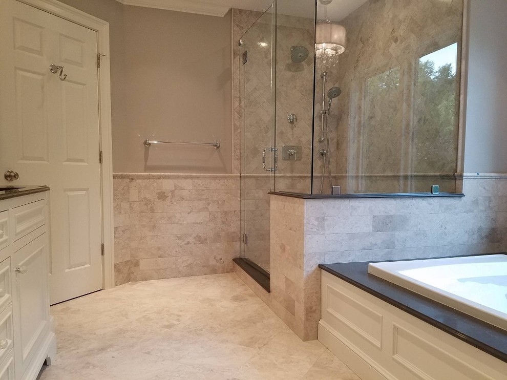 Example of a large classic master gray tile and limestone tile limestone floor and gray floor drop-in bathtub design in Bridgeport with furniture-like cabinets, beige cabinets, a two-piece toilet, gray walls, an undermount sink, quartz countertops and a hinged shower door