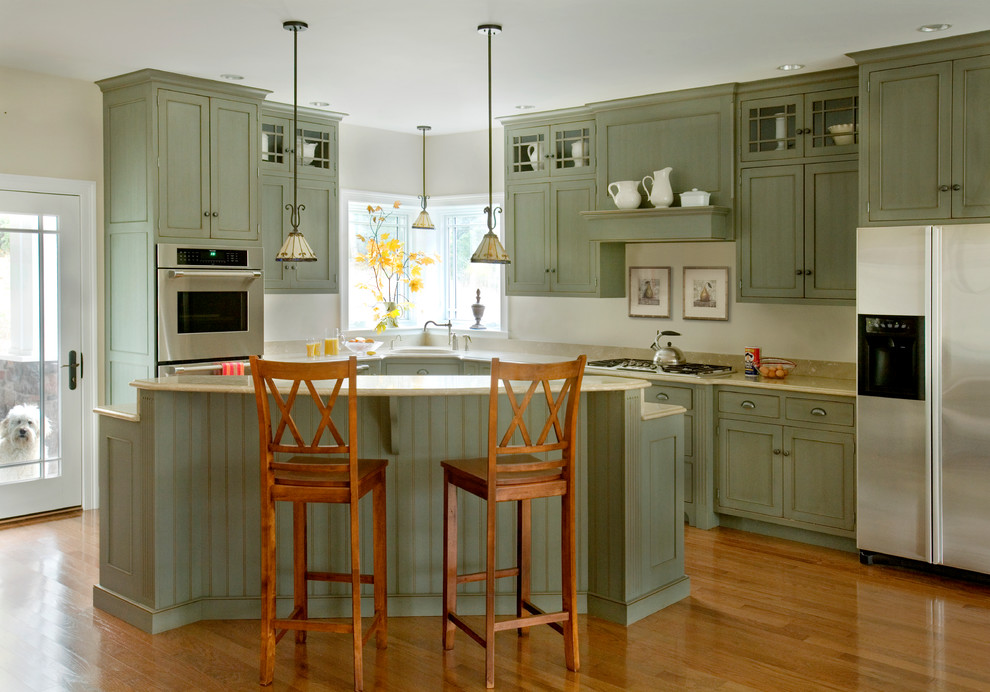 Photo of a mid-sized traditional l-shaped eat-in kitchen in Boston with recessed-panel cabinets, green cabinets, stainless steel appliances and medium hardwood floors.