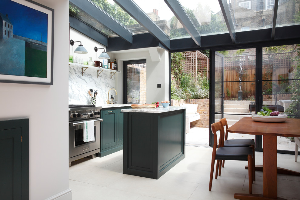 Photo of an eclectic galley eat-in kitchen in London with a drop-in sink, shaker cabinets, green cabinets, marble benchtops, marble splashback, stainless steel appliances, limestone floors and with island.
