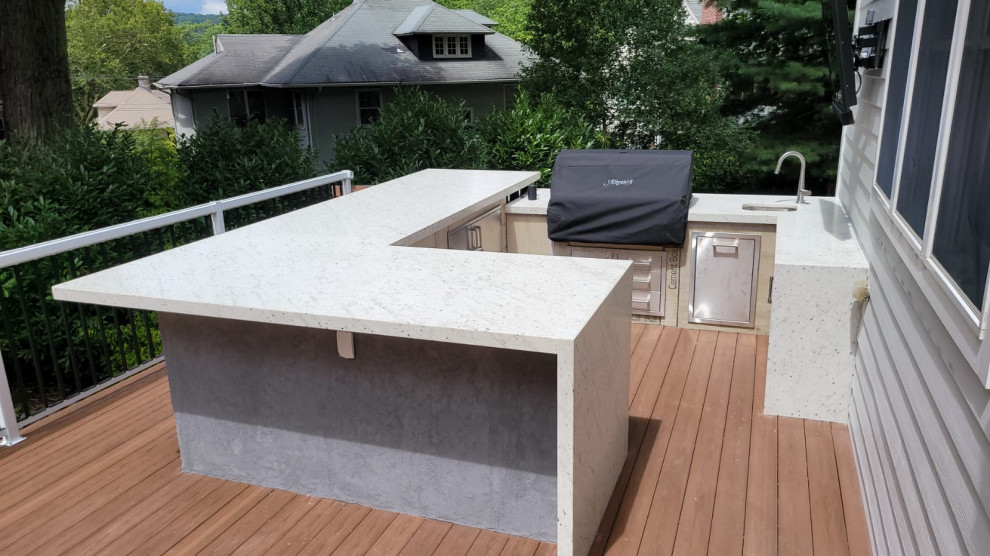 Example of a large trendy backyard patio kitchen design in New York with decking and no cover