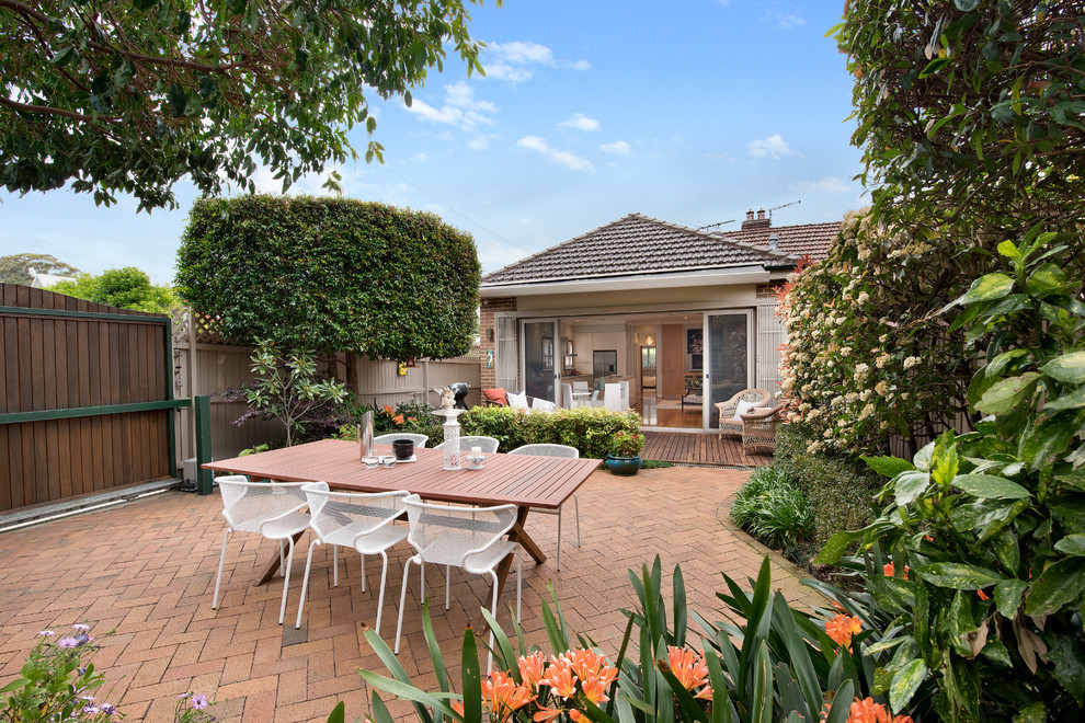 This is an example of a transitional courtyard patio in Sydney with brick pavers.