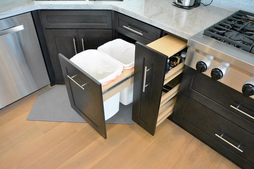 Example of a large transitional u-shaped medium tone wood floor and brown floor kitchen design in San Diego with an undermount sink, shaker cabinets, dark wood cabinets, quartz countertops, white backsplash, subway tile backsplash, stainless steel appliances and an island