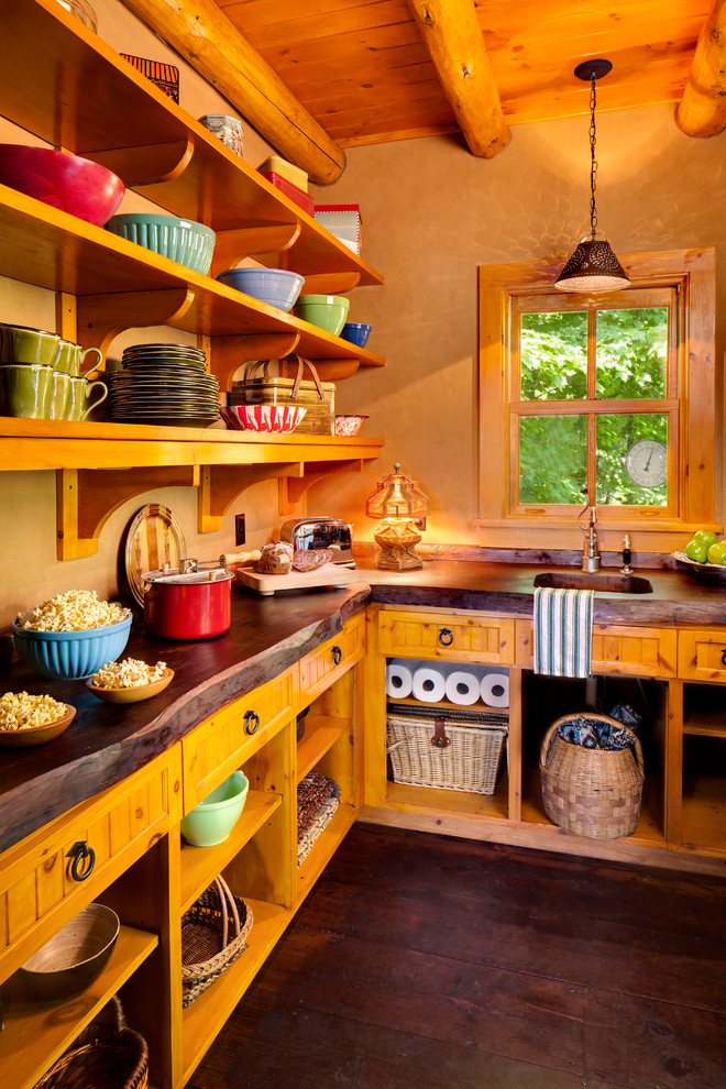 Country kitchen pantry in Milwaukee with a single-bowl sink, open cabinets, medium wood cabinets, wood benchtops, dark hardwood floors and brown floor.