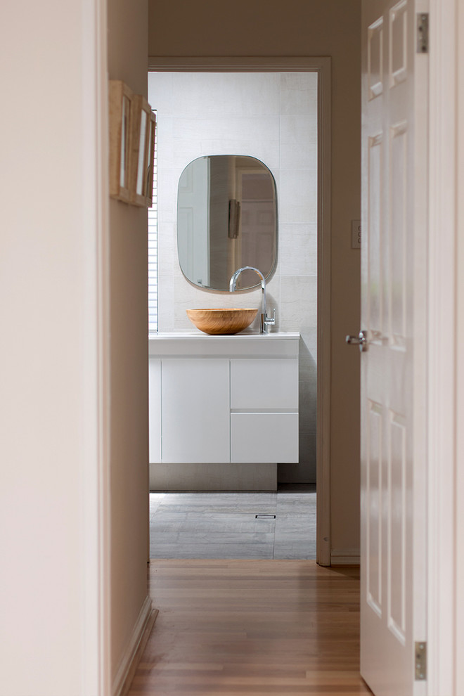 This is an example of a small scandinavian bathroom in Perth with white cabinets, a drop-in tub, beige tile, porcelain tile, porcelain floors and engineered quartz benchtops.