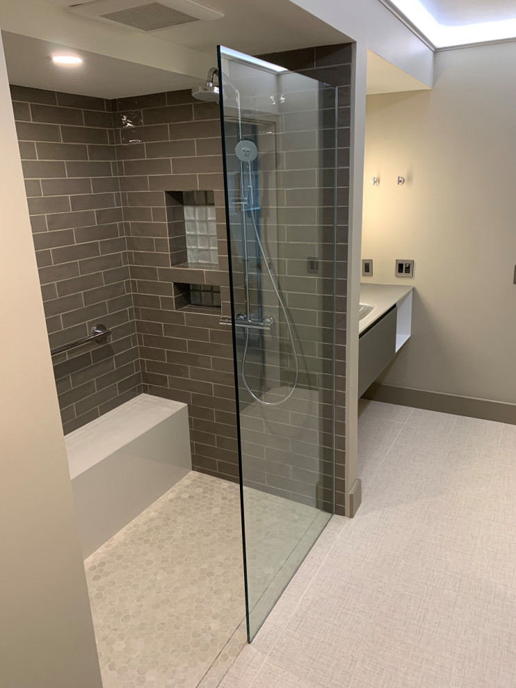 Mid-sized contemporary master bathroom in Seattle with open cabinets, grey cabinets, a curbless shower, a wall-mount toilet, grey walls, porcelain floors, an integrated sink, glass benchtops, beige floor, an open shower and green benchtops.