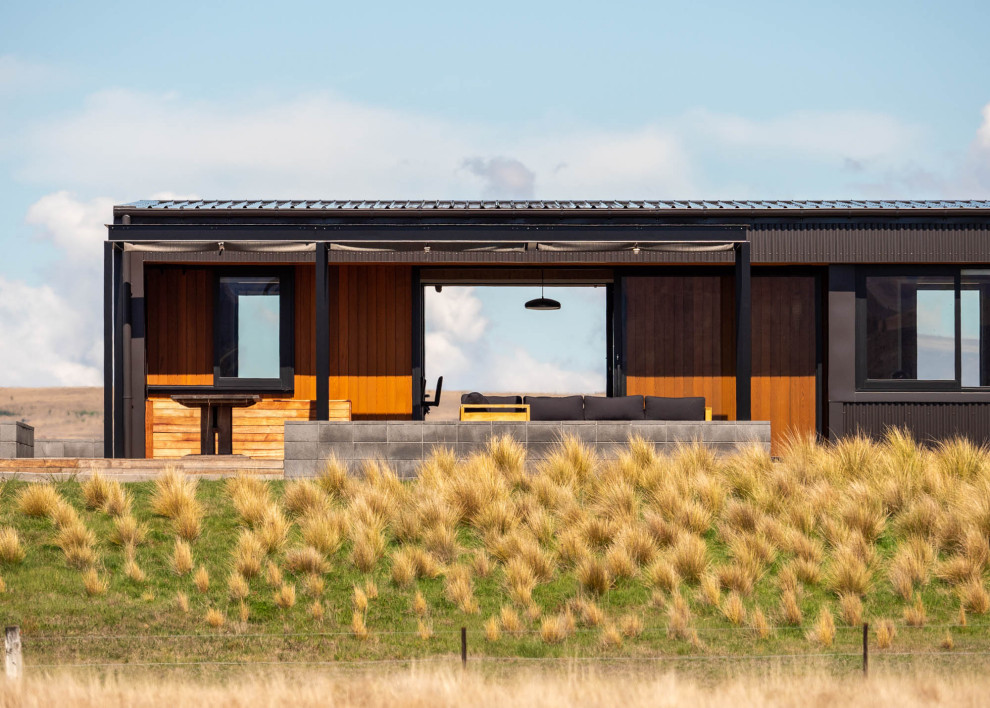 Design ideas for a Small modern One-storey Black house exterior With a Clipped Gable Roof, a Metal Roof and a Black Roof.