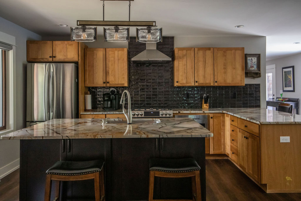 Inspiration for an eat-in kitchen in Grand Rapids with an undermount sink, shaker cabinets, medium wood cabinets, granite benchtops, black splashback, ceramic splashback, stainless steel appliances, vinyl floors, with island, brown floor and multi-coloured benchtop.
