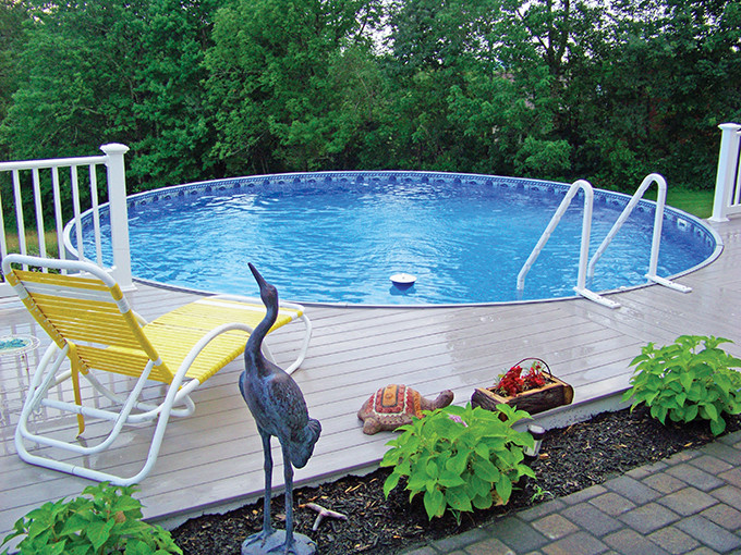 Mid-sized traditional backyard custom-shaped aboveground pool in Other with decking.