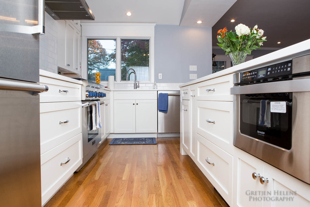 Transitional eat-in kitchen photo with an undermount sink, shaker cabinets, white cabinets, quartz countertops, white backsplash, subway tile backsplash, stainless steel appliances and an island