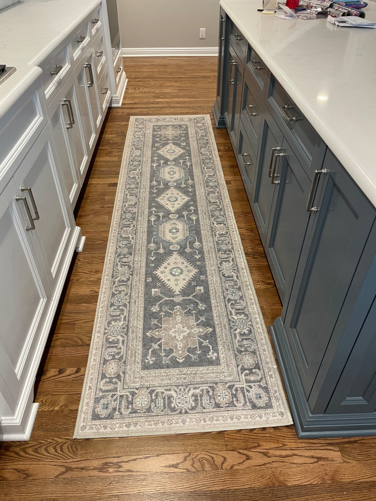 Example of a transitional light wood floor kitchen design in Omaha with blue cabinets, white backsplash, subway tile backsplash, stainless steel appliances, an island and white countertops