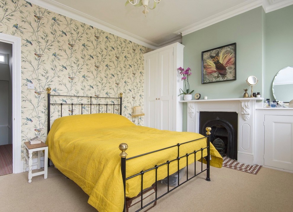 Inspiration for a traditional bedroom in London with green walls, carpet, a standard fireplace and beige floor.