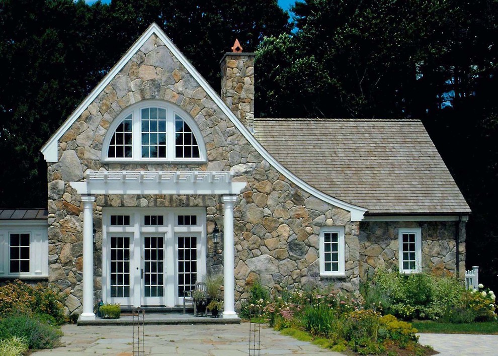 Photo of a mid-sized traditional two-storey beige house exterior in Boston with stone veneer, a gable roof and a shingle roof.