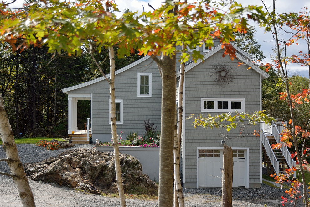 This is an example of a mid-sized transitional two-storey grey exterior in Portland Maine with vinyl siding.