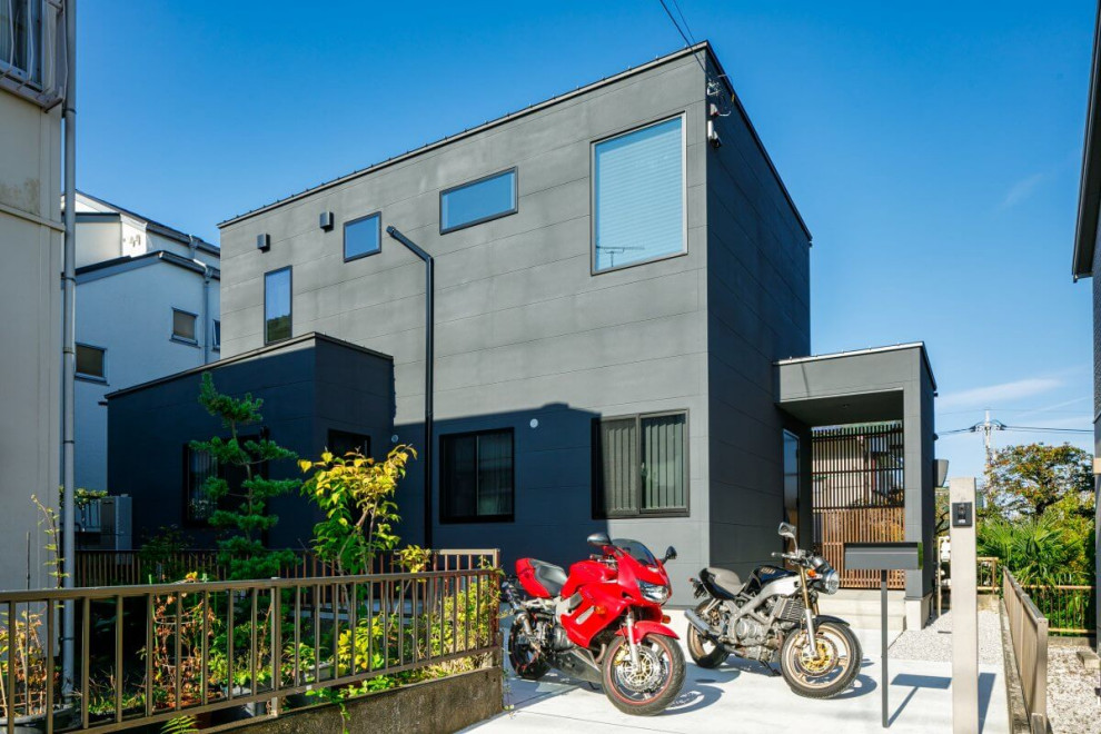 Mittelgroßes, Zweistöckiges Industrial Einfamilienhaus mit grauer Fassadenfarbe, Flachdach, Blechdach und schwarzem Dach in Tokio Peripherie