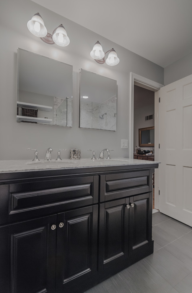 Mid-sized traditional master bathroom in Bridgeport with an undermount sink, raised-panel cabinets, dark wood cabinets, marble benchtops, a corner shower, a two-piece toilet, gray tile, porcelain tile, blue walls and porcelain floors.