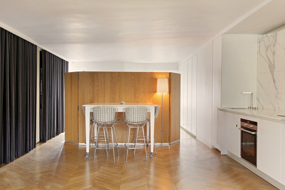 Mid-sized contemporary open plan dining in Paris with light hardwood floors and white walls.