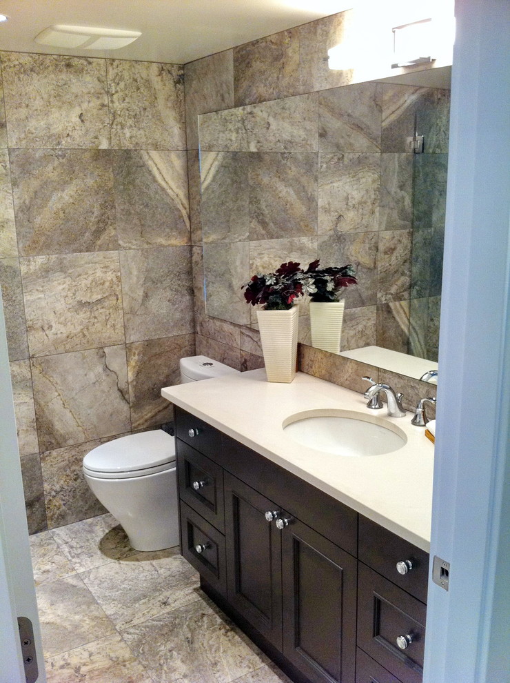 This is an example of a small contemporary 3/4 bathroom in Vancouver with shaker cabinets, black cabinets, an alcove shower, beige tile, stone tile, beige walls, porcelain floors, an undermount sink, solid surface benchtops and a two-piece toilet.