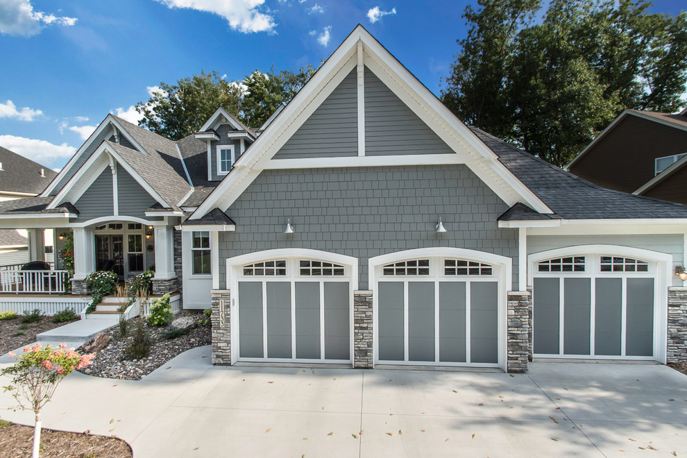Design ideas for a large arts and crafts attached three-car garage in Minneapolis.