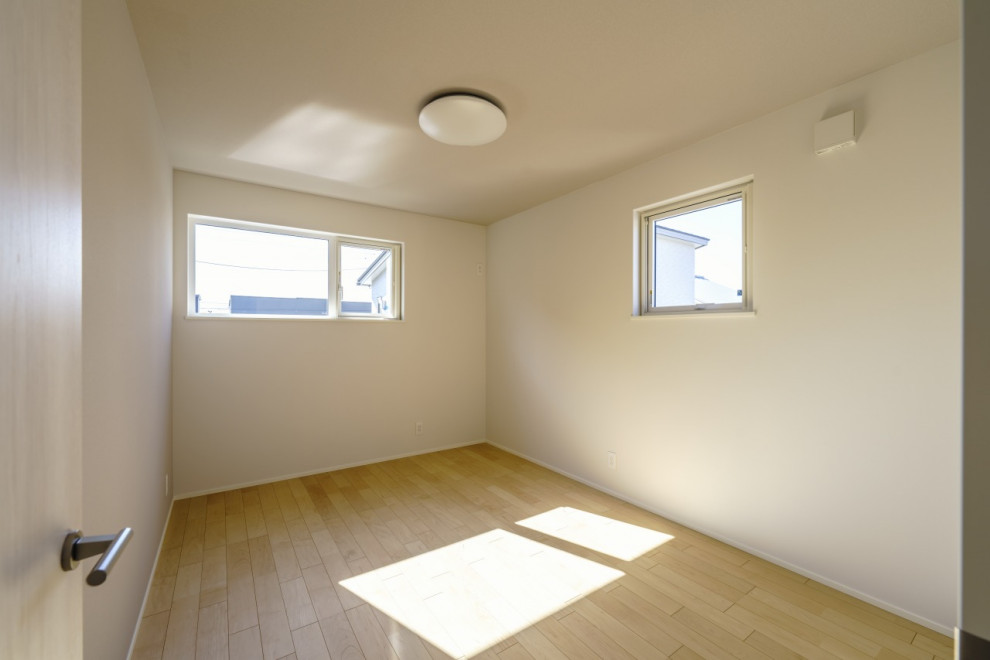 Photo of a mid-sized modern gender-neutral kids' room in Other with light hardwood floors, brown floor, wallpaper and wallpaper.