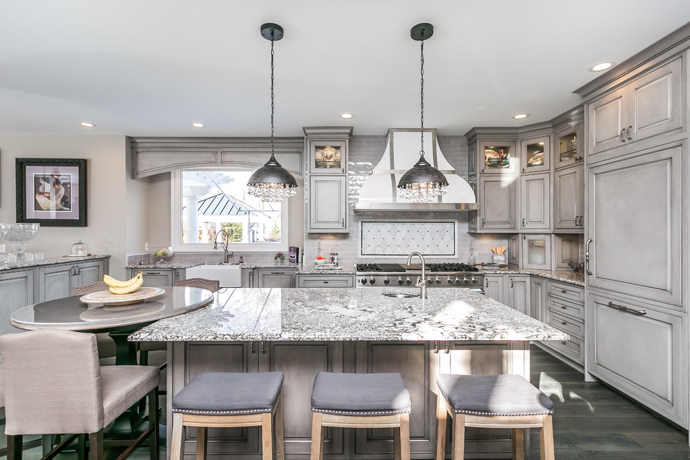 Design ideas for a large traditional eat-in kitchen in Baltimore with a farmhouse sink, grey cabinets, granite benchtops, raised-panel cabinets, multi-coloured splashback, panelled appliances and dark hardwood floors.