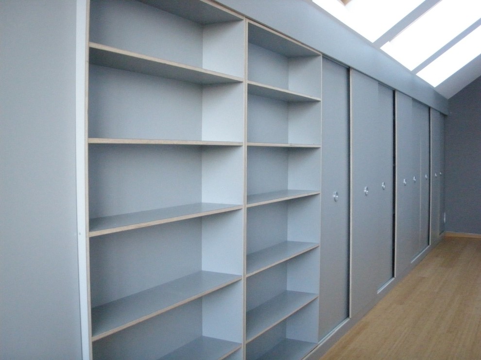 Modern built-in wardrobe in Other with grey cabinets and bamboo floors.